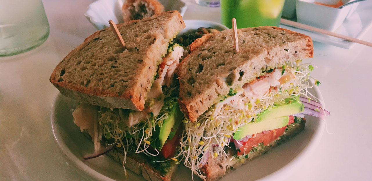 The Big Liho sandwich is filled with avocado, sprouts, homemade pesto, bacon, and more.